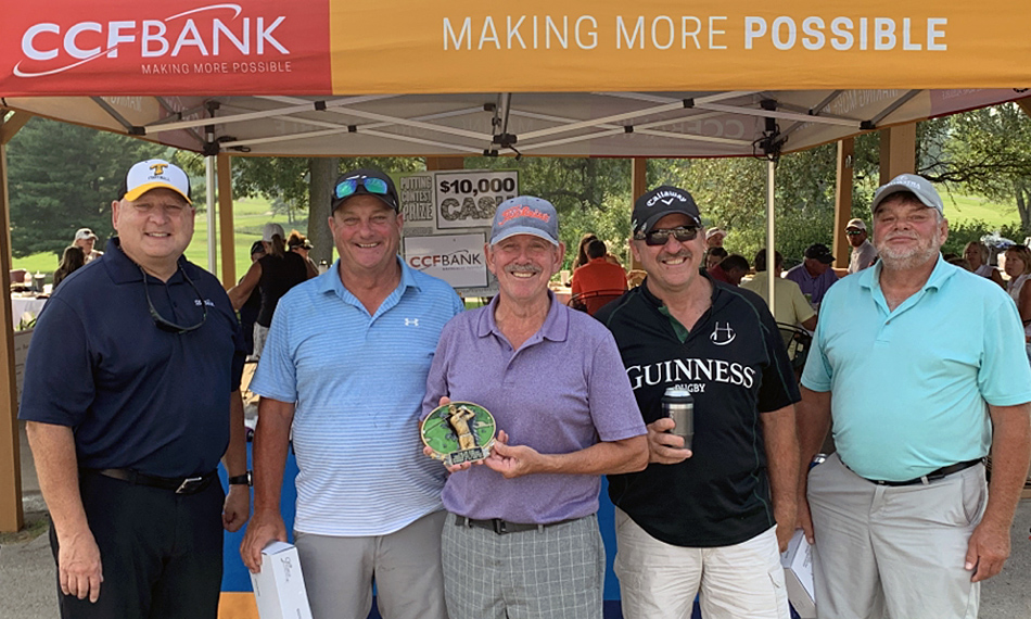 The winning team of the golf outing are presented with trophies