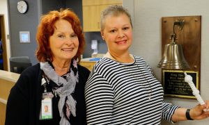 Tomah Health Infusion and Pulmonary Services Director poses with a Tomah resident who donated a bell to the department