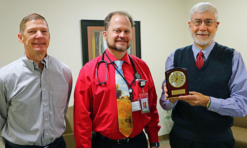 Oak Moser (left) and Jeffrey Cavaness M.D. (center) present a recognition clock to Dr. Michael Saunders M.D. for years of service to Tomah Health