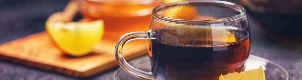 A cup of tea on a table with a slice of lemon