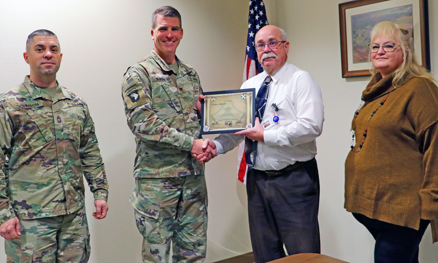 Officials from Fort McCoy present Tomah Health admin staff a certificate of appreciation