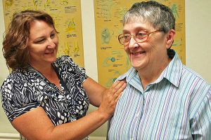 A therapist assisting and elderly woman