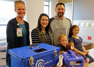 Tomah Health Women's Health Services director poses with a Tomah family that donated a Cuddle Cat to the hospital