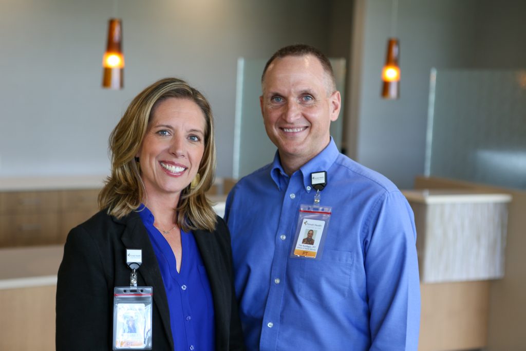 Emily Wall and Tim Kortbein posing standing together in the hospital