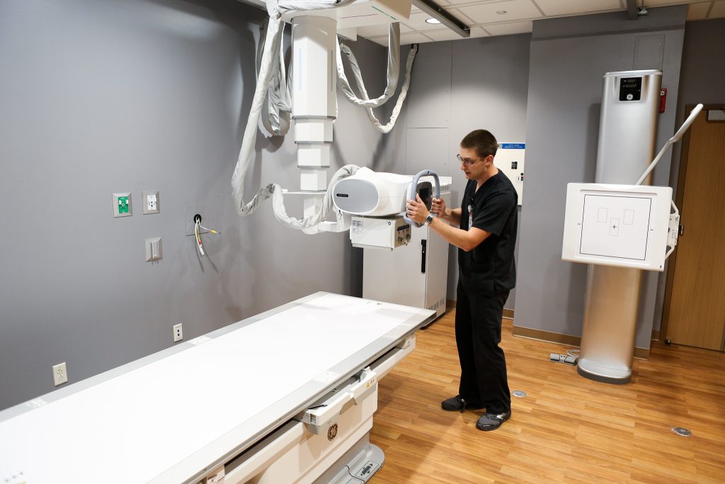 A man using an imaging machine in a hospital room