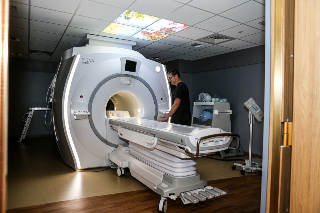 A man with a CT scanning machine in a hospital room