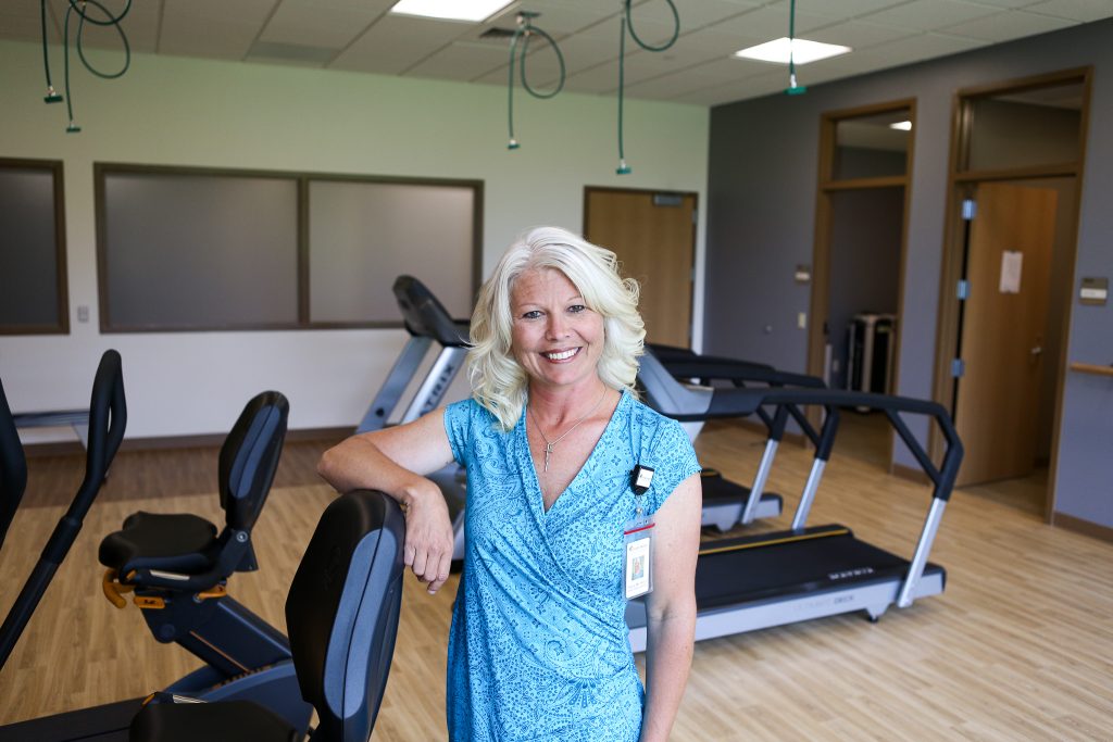 Shana Steele standing with her arm resting on rehabilitions excercise equipment