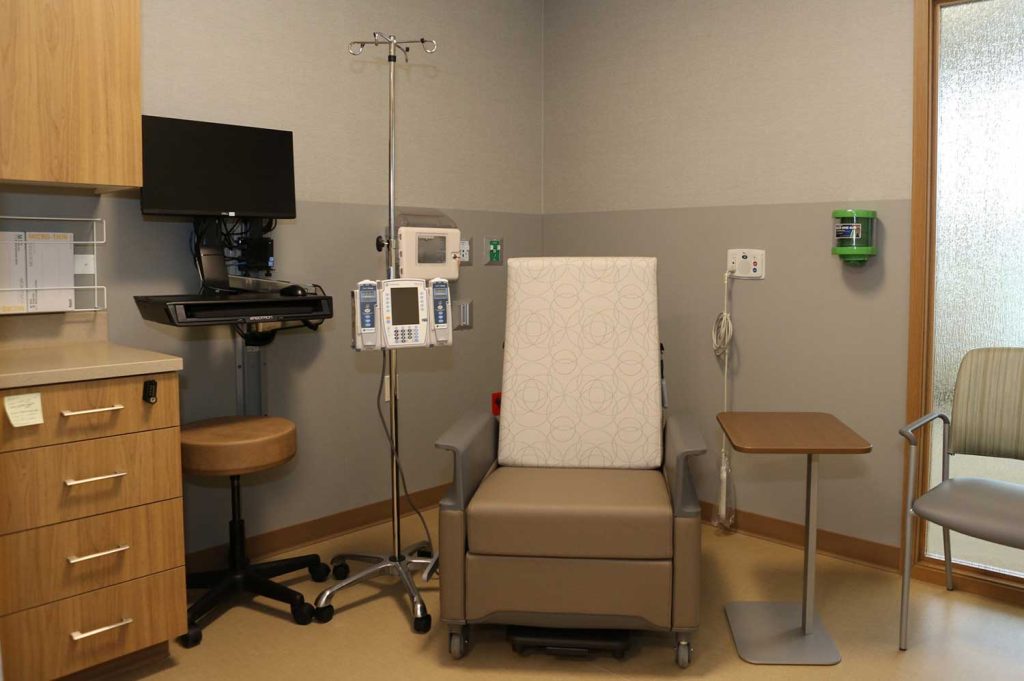 A comfortable chair next to infusion equipment in a hospital room