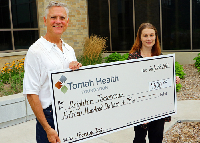 Tomah Health Community Foundation vice president presents a ceremonial check to the Brighter Tomorrows program coordinator.