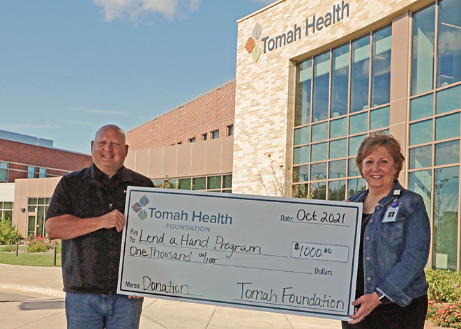 Tomah Health Community Foundation president presents a ceremonial check to Tomah Health quality director
