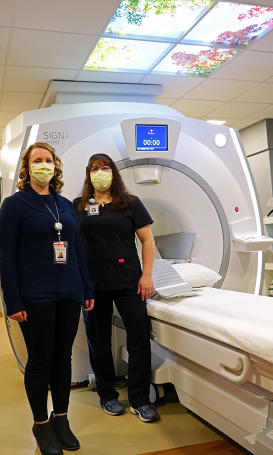 Tomah Health Images Services Coordinator and Multi-Modality Lead pose with the MRI unit at Tomah Health