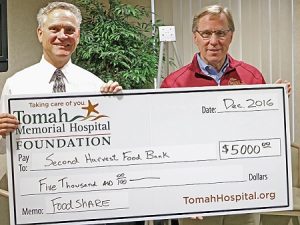 Tomah Health Foundation vice president presents a ceremonial check to Second Harvest Foodbank's CEO/President.