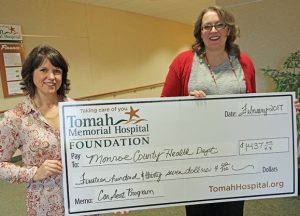 Tomah Health Foundation board secretary presents a ceremonial check to a public health nurse