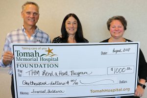 Tomah Health Foundation officials present a ceremonial check to the Lend a Hand program