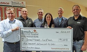 Tomah Health officials present a ceremonial check to the Second Harvest Foodbank president and CEO