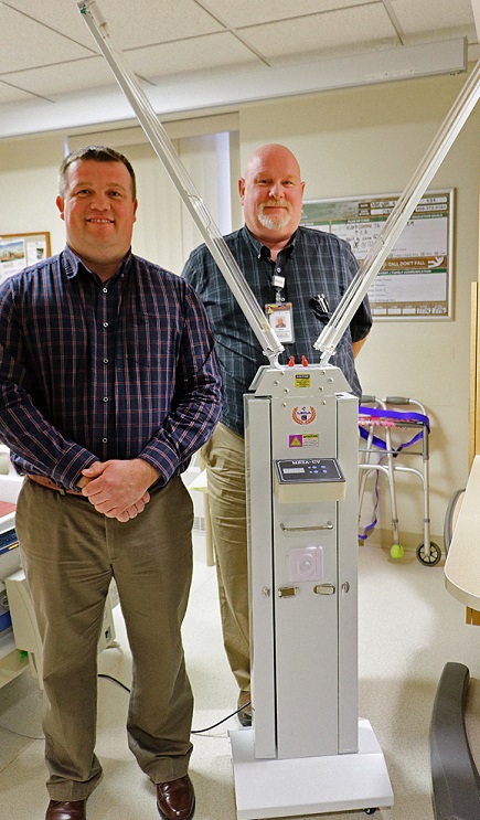 Tomah Health emergency preparedness specialist and hospital environmental services coordinator pose with a mobile room sanitizer