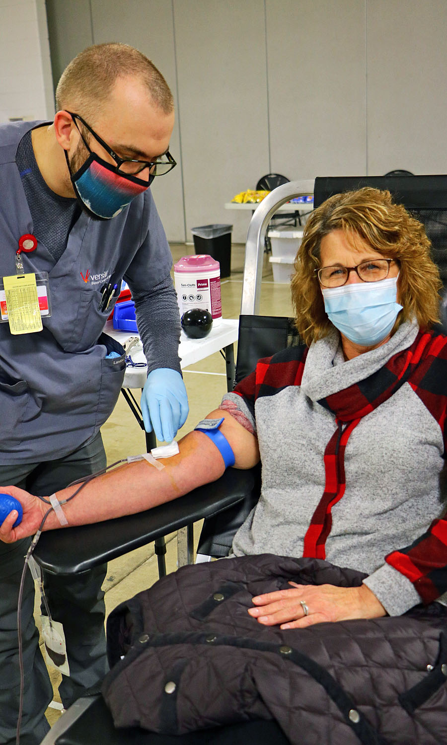 A Tomah resident donates blood at a blood drive. She and the nurse are masked.