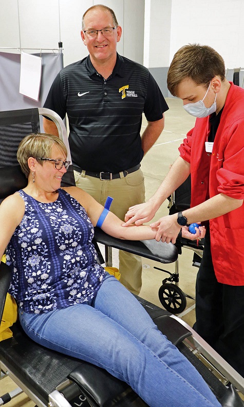 Wendy and Jeff Von Haden pose for the camera as Wendy gets her arm pricked by a blood technician