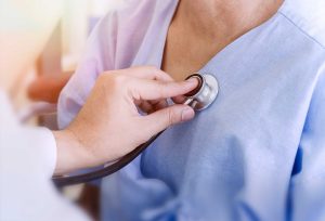 A doctor listening to someone's heartbeat with a stethoscope