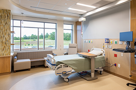 A Tomah Health hospital patient room with a large window and swing bed