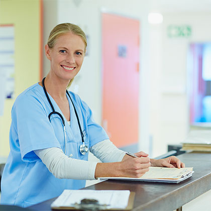 Smiling Nurse working on charts