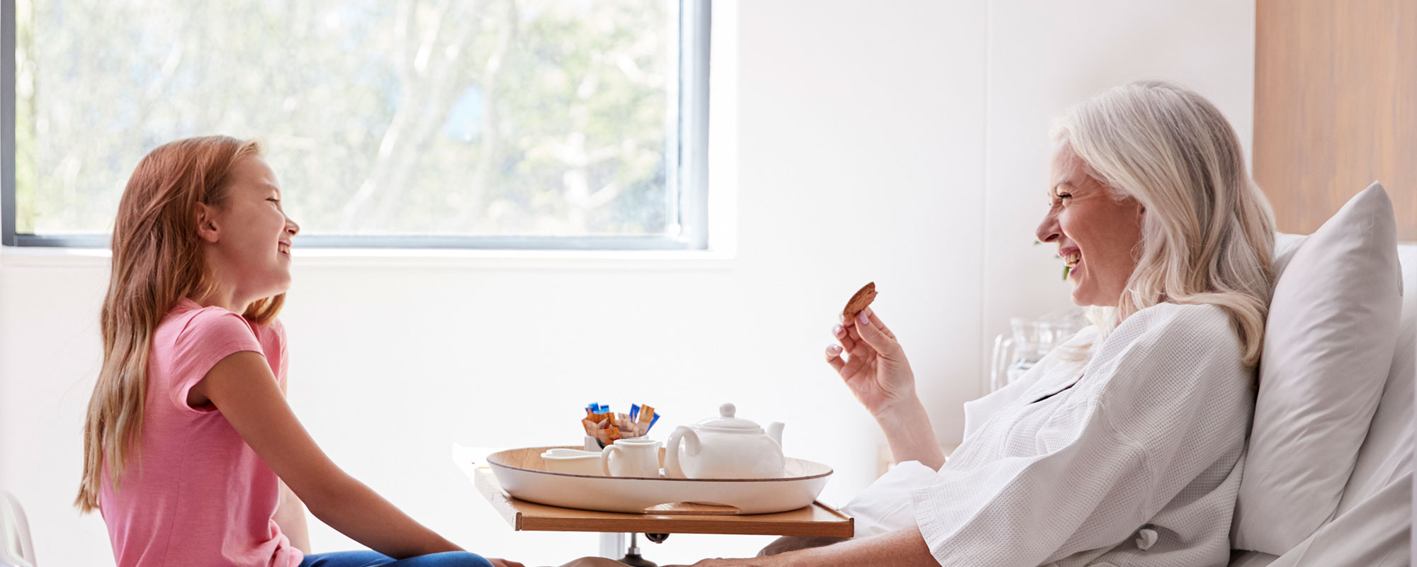 Child and grandmother talking in hospital room