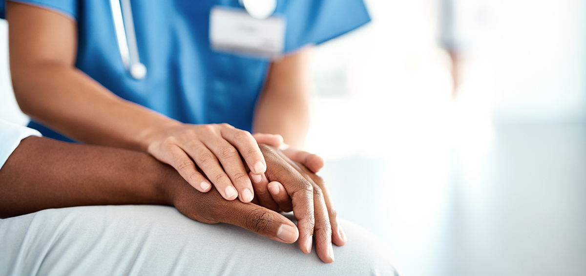 A nurse holding a patients hand