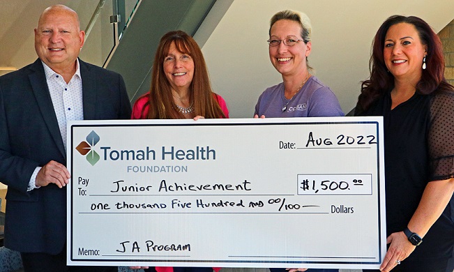 Community members hold a giant check for $1,200 from the Tomah Health Foundation