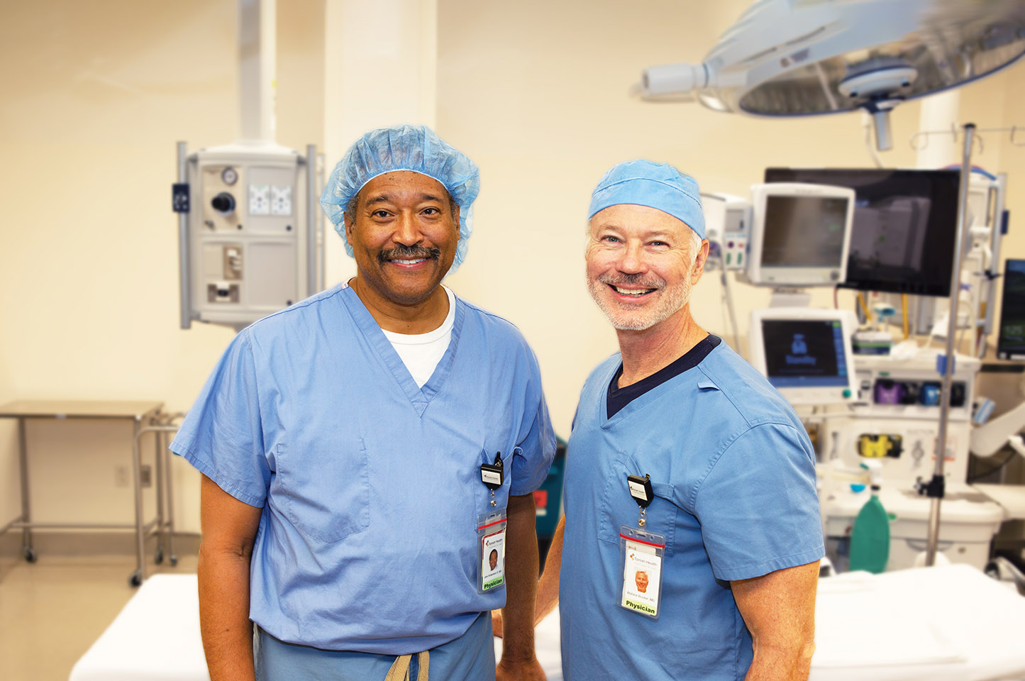 Dr. John Robertson, III, MD and Dr. Wallace Brucker, MD smile at the camera in the Tomah Health surgical suite. Both provide expert surgical care, close to home.